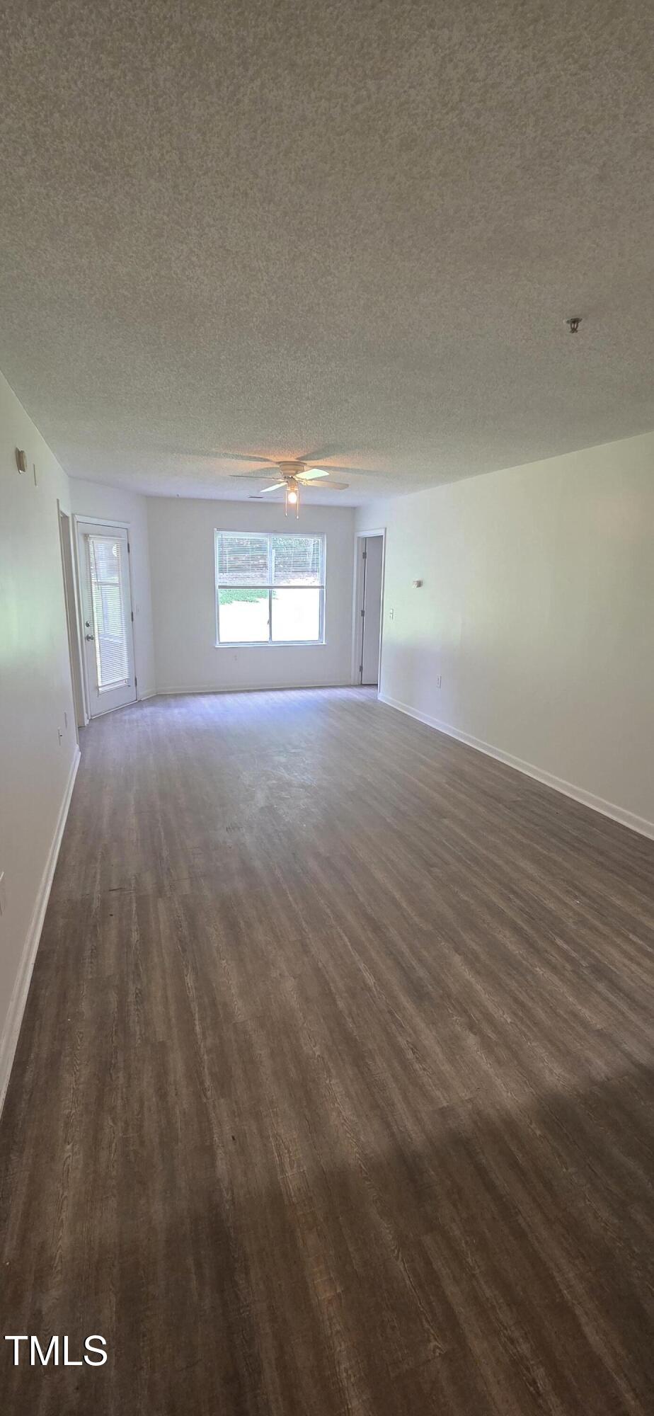 1401 Collegiate Circle, Unit 104 Raleigh, NC 27606 - Photo 11 of 29 an empty room with wooden floor and windows