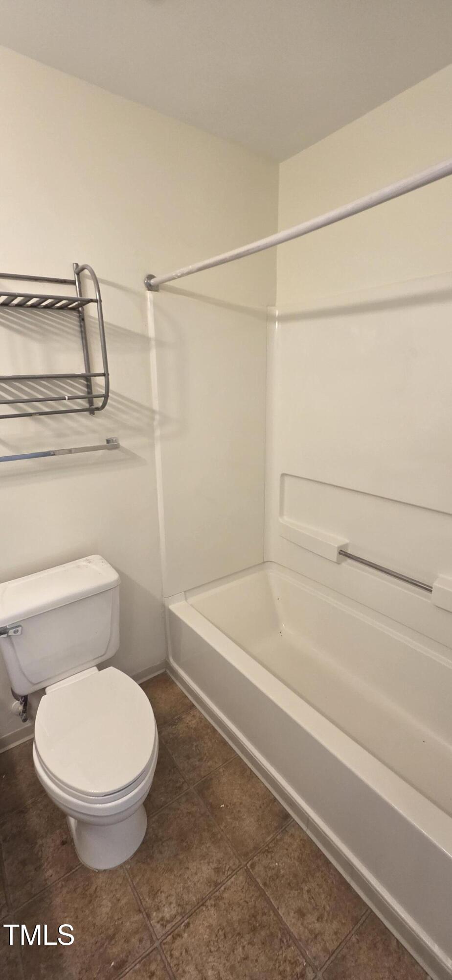 1401 Collegiate Circle, Unit 104 Raleigh, NC 27606 - Photo 16 of 29 a white toilet and tub sitting next to a bathroom sink