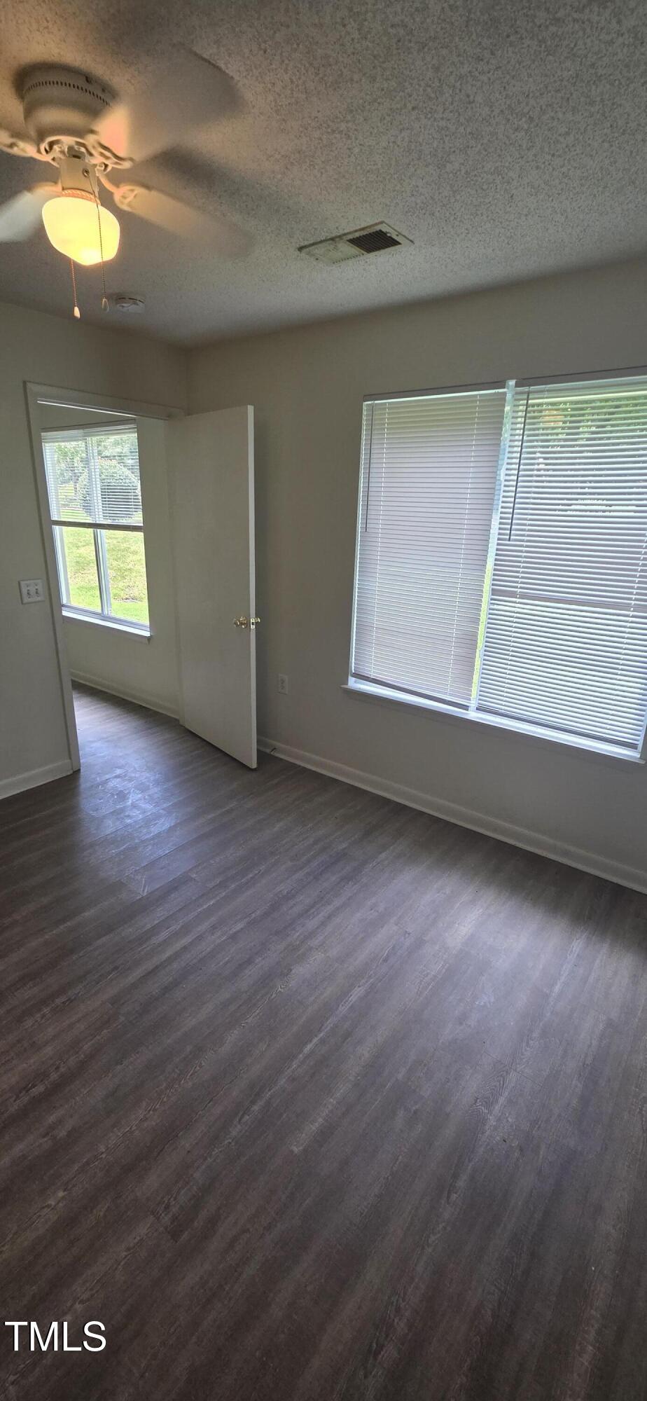 1401 Collegiate Circle, Unit 104 Raleigh, NC 27606 - Photo 19 of 29 an empty room with wooden floor and windows