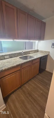 a kitchen with granite countertop a sink and a stove