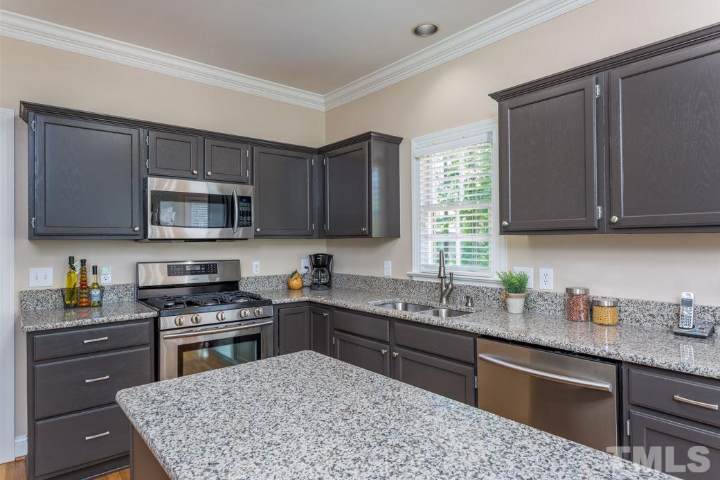 11817 Radner Way Raleigh, NC 27613 - Photo 1 of 15 a kitchen with stainless steel appliances granite countertop a stove a sink dishwasher and a microwave oven with cabinets