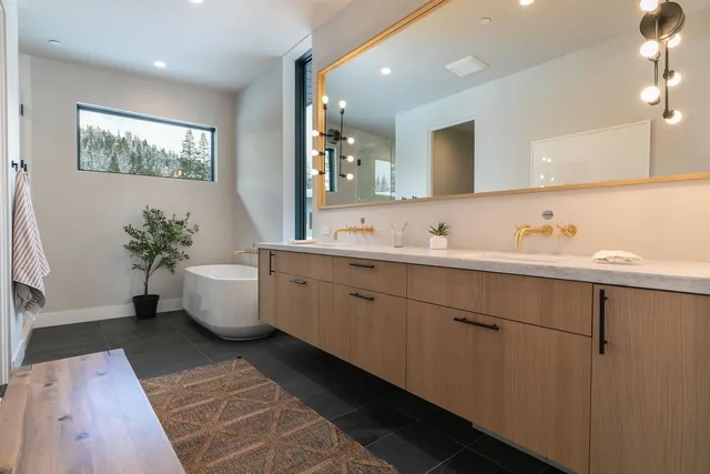 a spacious bathroom with a double vanity sink a mirror and a bathtub