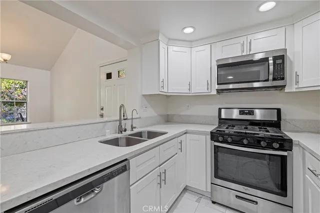 a kitchen with stainless steel appliances a stove a microwave and sink