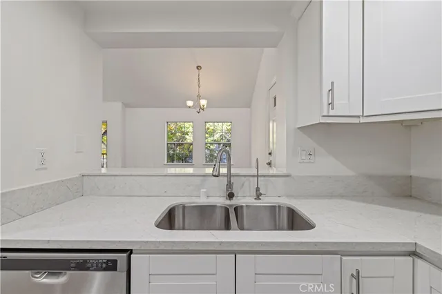 a view with granite countertop a sink and cabinets