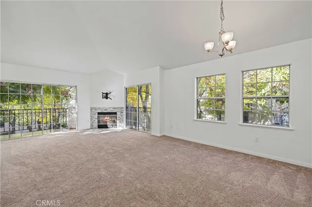 a view of an empty room with a fireplace and a window