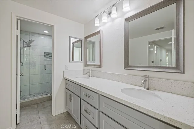 a bathroom with double sink and a mirror