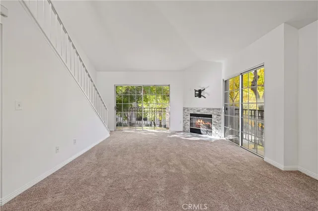 a view of an empty room with a fireplace and a window