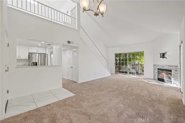 a view of an empty room with a fireplace and a window