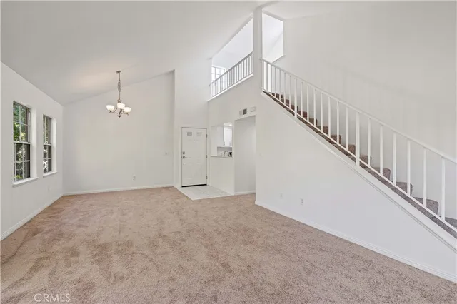 a view of an empty room with chandelier fan