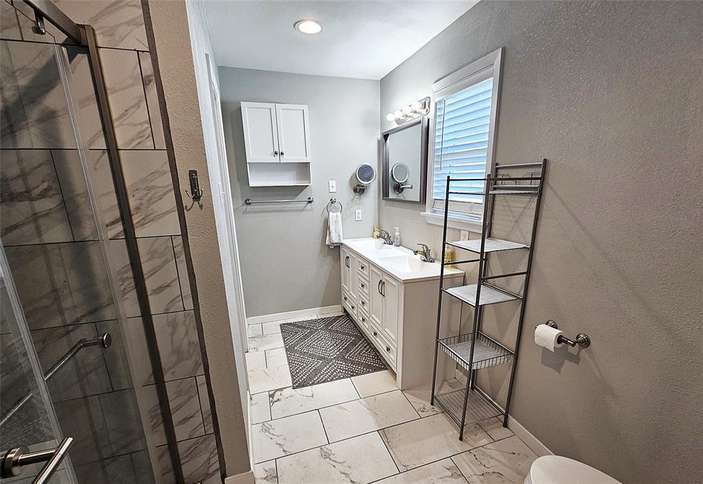 1205 West Trinity Street Groesbeck, TX 76642 - Photo 11 of 28 a bathroom with a sink toilet and shower