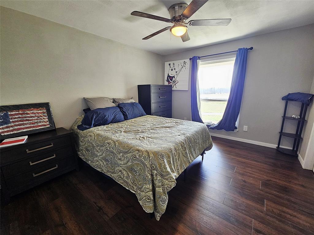 1205 West Trinity Street Groesbeck, TX 76642 - Photo 15 of 28 a bedroom with a bed and a mirror on the dresser