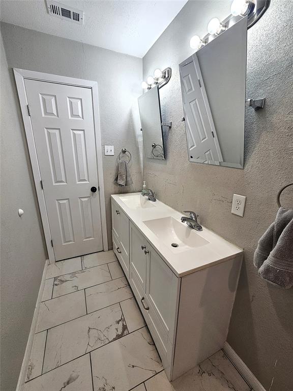 1205 West Trinity Street Groesbeck, TX 76642 - Photo 18 of 28 a bathroom with a sink a toilet a mirror and vanity