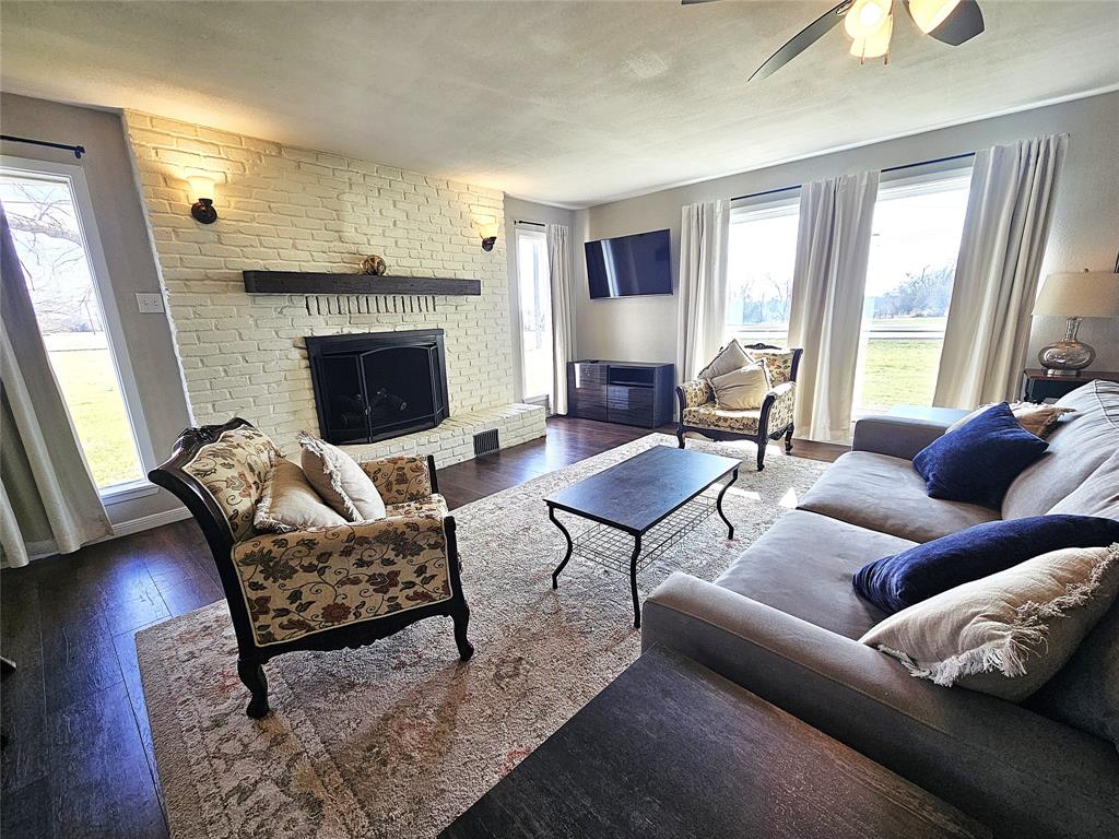 1205 West Trinity Street Groesbeck, TX 76642 - Photo 5 of 28 a living room with furniture a fireplace and a large window