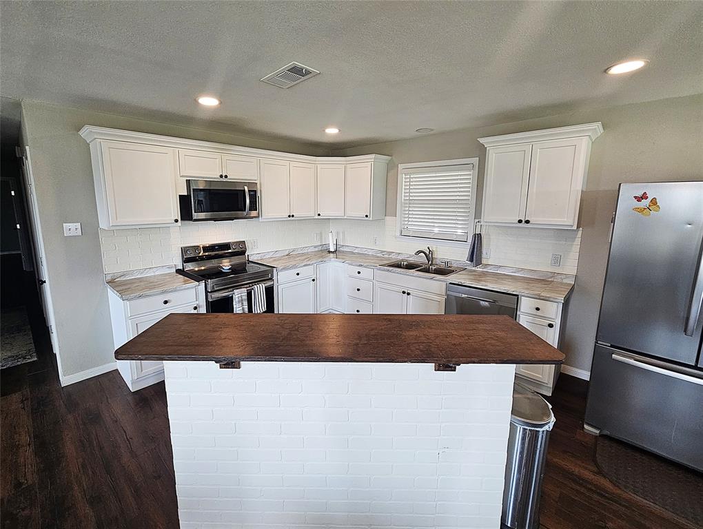 1205 West Trinity Street Groesbeck, TX 76642 - Photo 6 of 28 a kitchen with kitchen island a sink stainless steel appliances and counter space