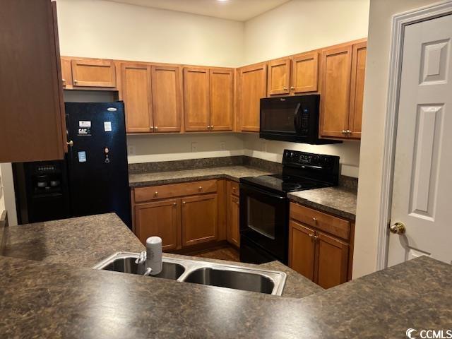 328 Kiskadee Loop, Unit 15C Conway, SC 29526 - Photo 2 of 18 Kitchen featuring dark countertops, black appliances, and brown cabinets