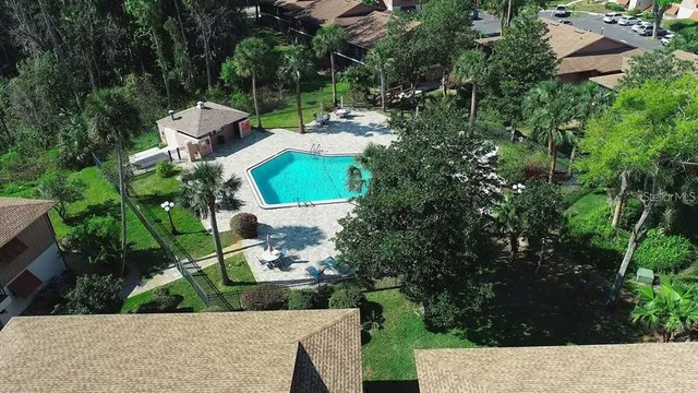 an aerial view of residential house with outdoor space and trees all around