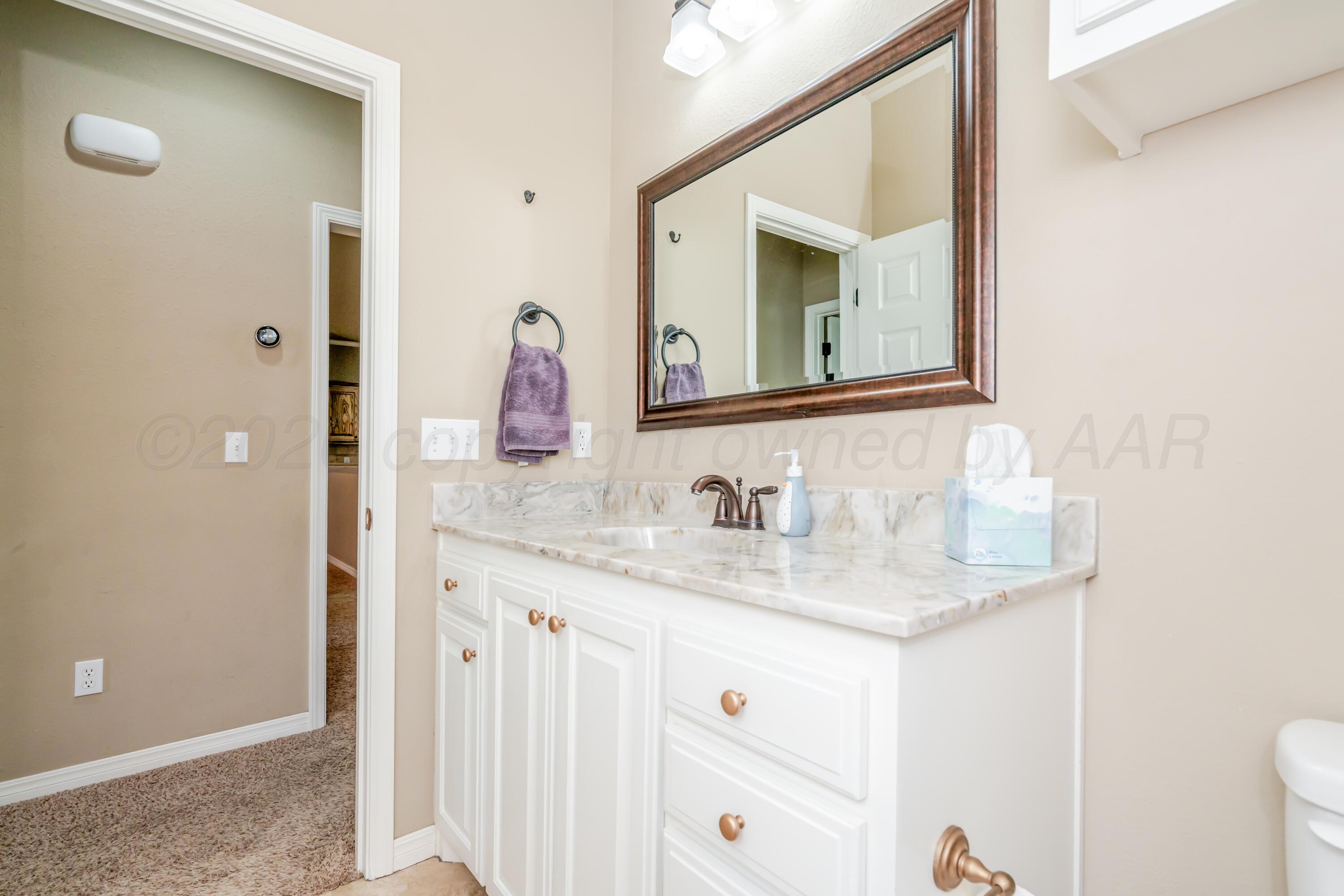 6814 Tivis Street Amarillo, TX 79119 - Photo 18 of 37 a bathroom with a granite countertop sink and a mirror