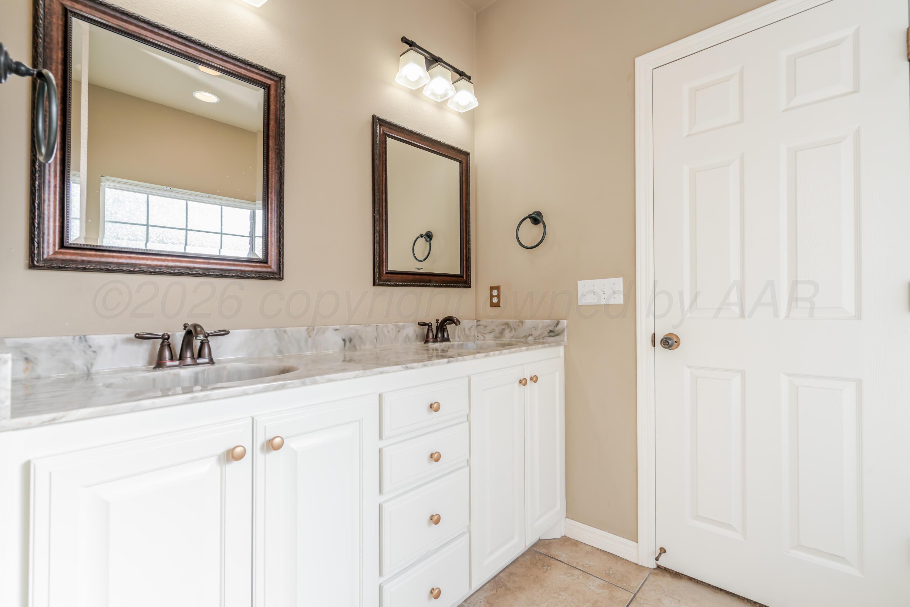 6814 Tivis Street Amarillo, TX 79119 - Photo 26 of 37 a bathroom with double sink and a mirror