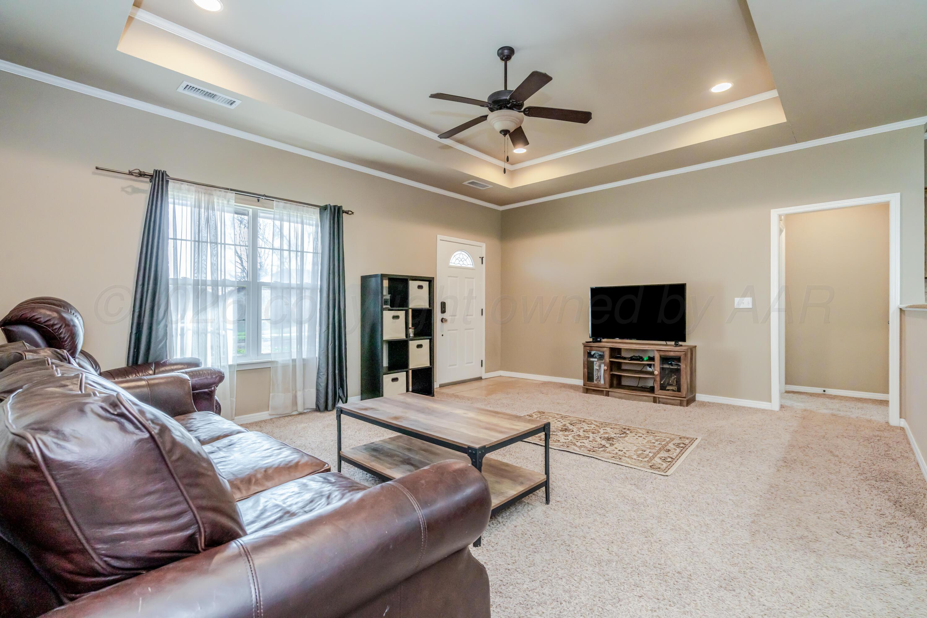 6814 Tivis Street Amarillo, TX 79119 - Photo 4 of 37 a living room with furniture a ceiling fan and a flat screen tv
