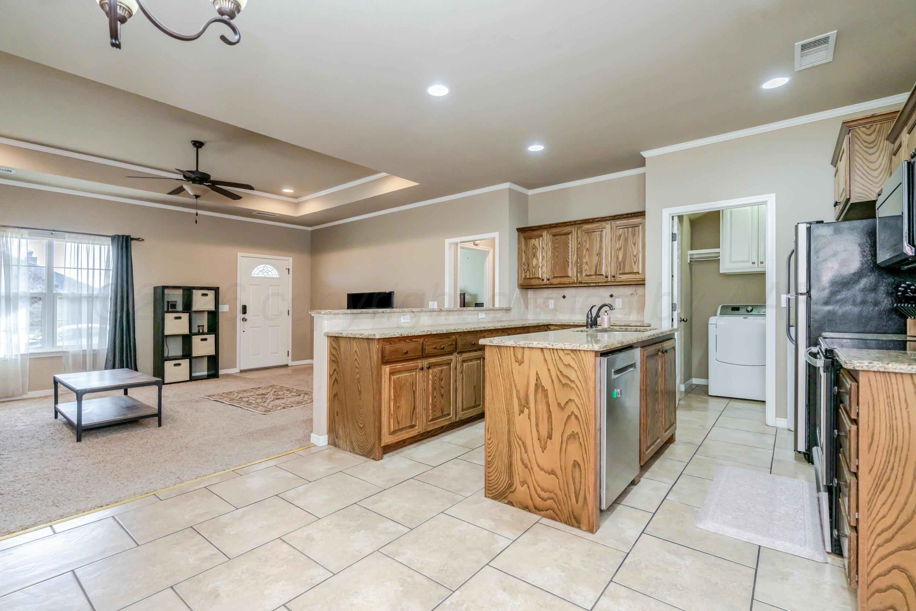 6814 Tivis Street Amarillo, TX 79119 - Photo 8 of 37 a large kitchen with kitchen island granite countertop a large counter top and sink