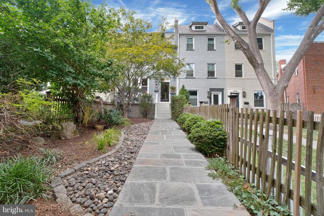 a front view of a house with a yard and potted plants