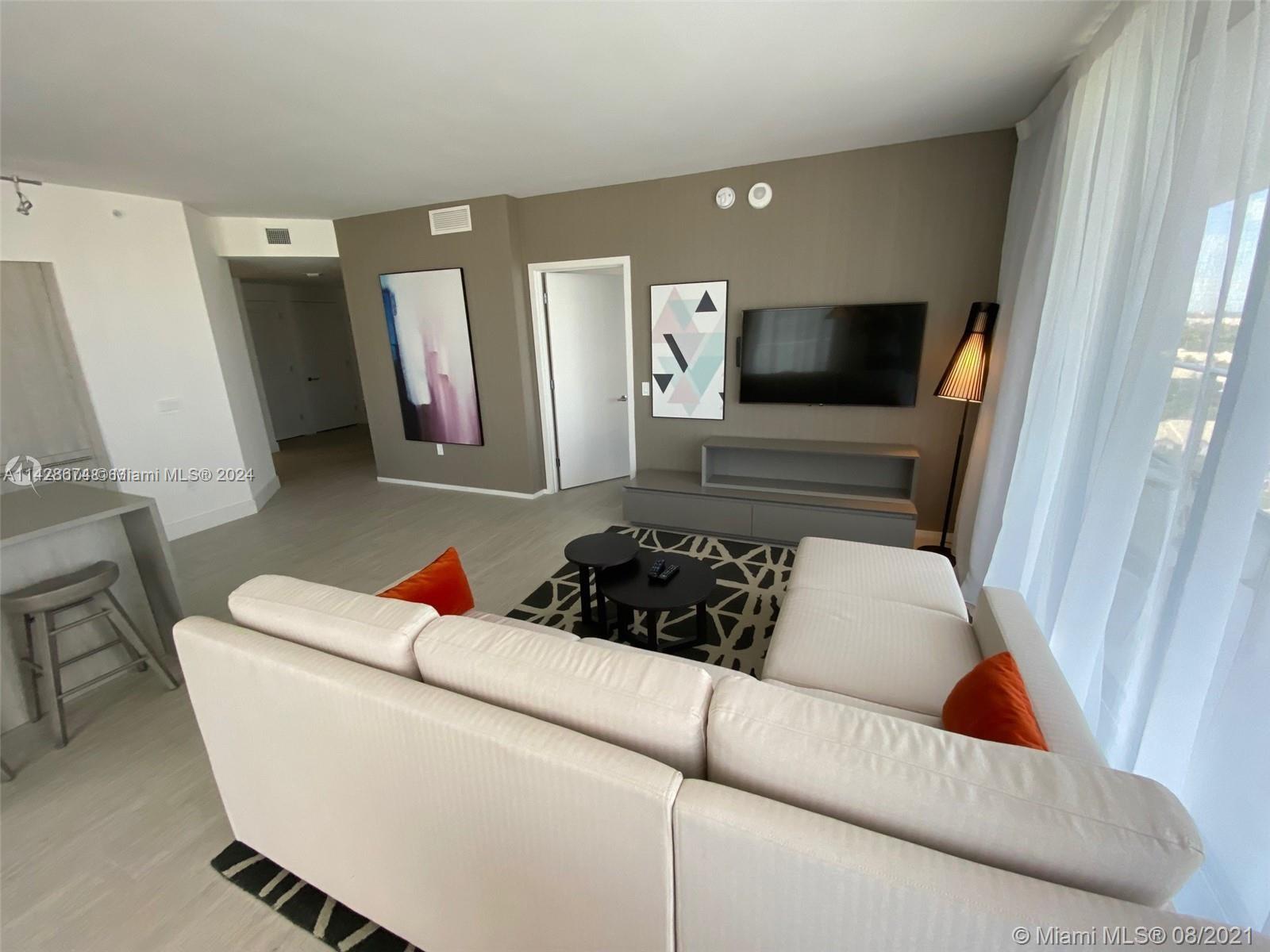 4010 South Ocean Drive, Unit R301 Hollywood, FL 33019 - Photo 12 of 18 a living room with furniture and a flat screen tv