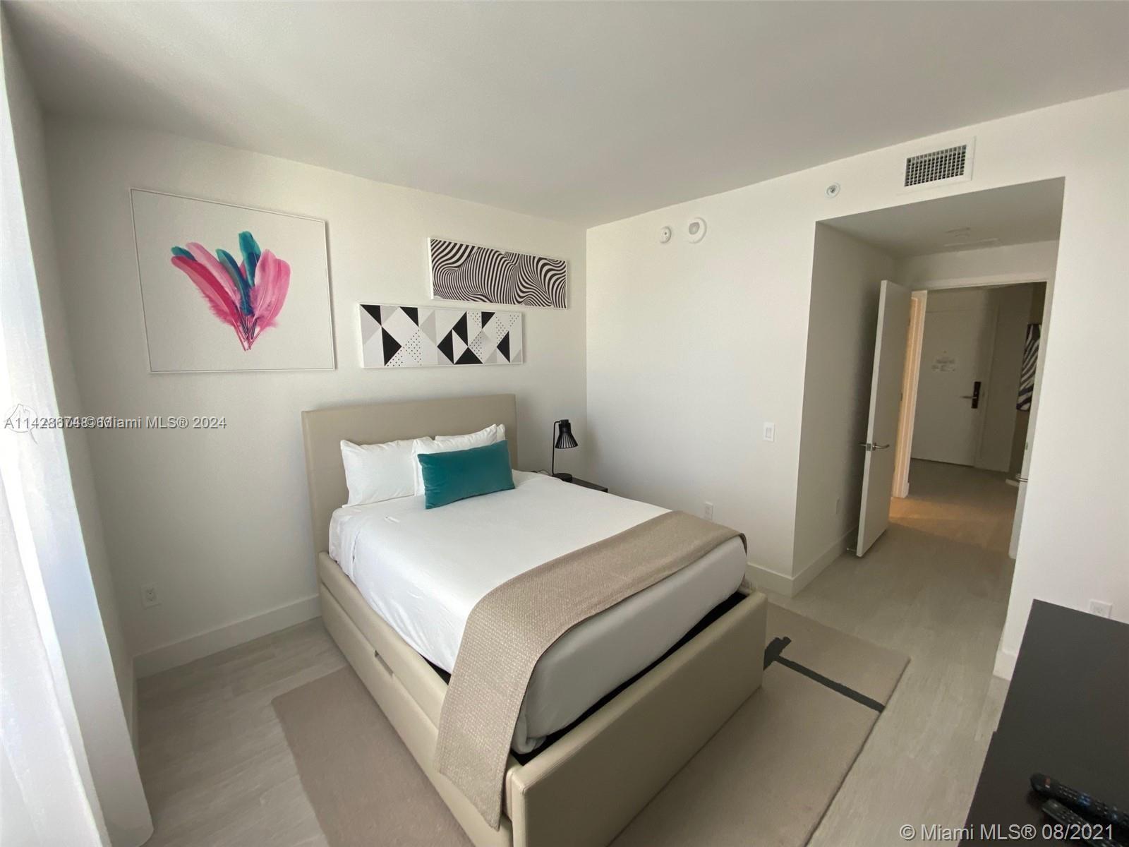 4010 South Ocean Drive, Unit R301 Hollywood, FL 33019 - Photo 14 of 18 a bedroom with a bed and cabinets