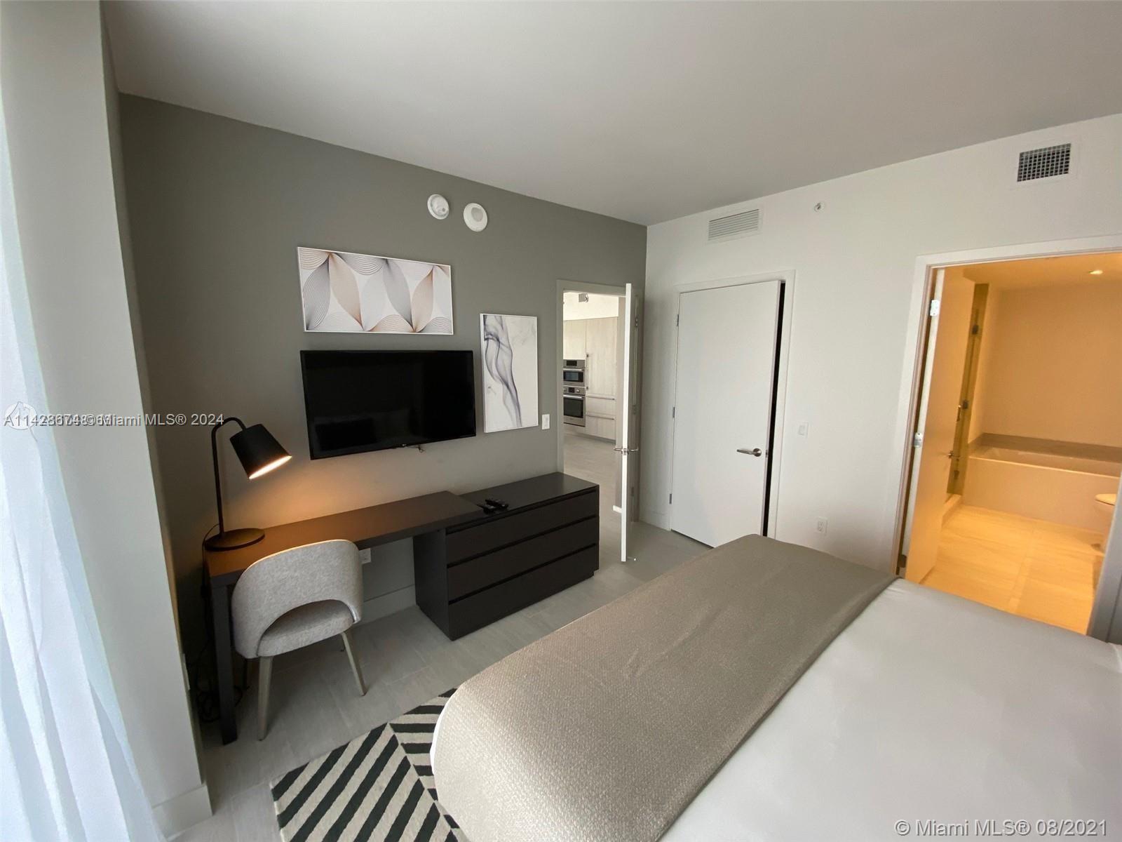 4010 South Ocean Drive, Unit R301 Hollywood, FL 33019 - Photo 15 of 18 a bedroom with a bed and wooden floor