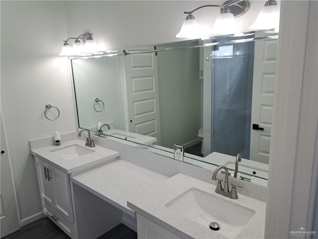 708 East 3rd Avenue Elsa, TX 78543 - Photo 14 of 33 Full bath featuring double vanity, a stall shower, toilet, and baseboards