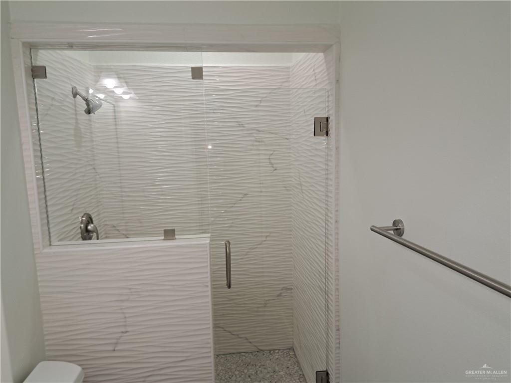 708 East 3rd Avenue Elsa, TX 78543 - Photo 18 of 33 Full bathroom with a shower stall, toilet, and speckled floor