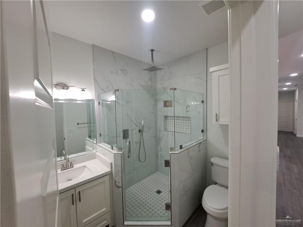 708 East 3rd Avenue Elsa, TX 78543 - Photo 25 of 33 Bathroom with a marble finish shower, vanity, and toilet