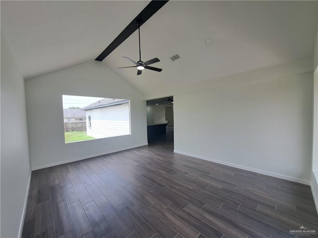 708 East 3rd Avenue Elsa, TX 78543 - Photo 7 of 33 Empty room featuring dark wood-style floors, baseboards, and a ceiling fan