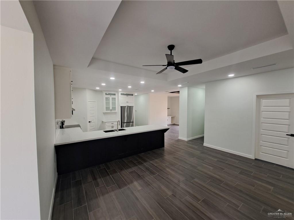 708 East 3rd Avenue Elsa, TX 78543 - Photo 10 of 33 Kitchen featuring freestanding refrigerator, recessed lighting, baseboards, a tray ceiling, and a peninsula