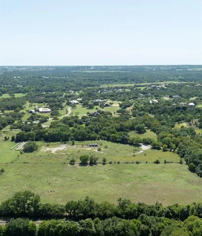 an aerial view of residential houses with outdoor space and trees
