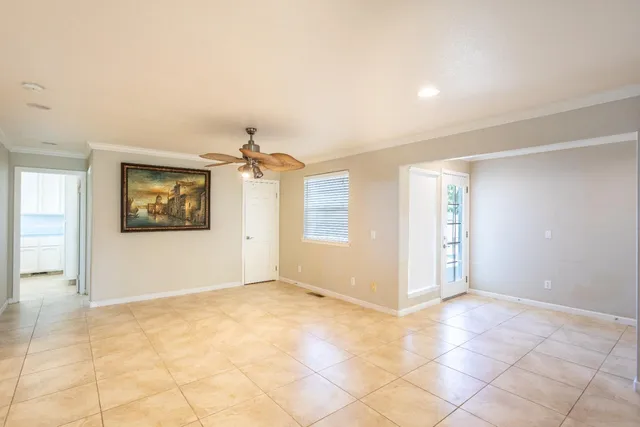 an empty room with windows and fan
