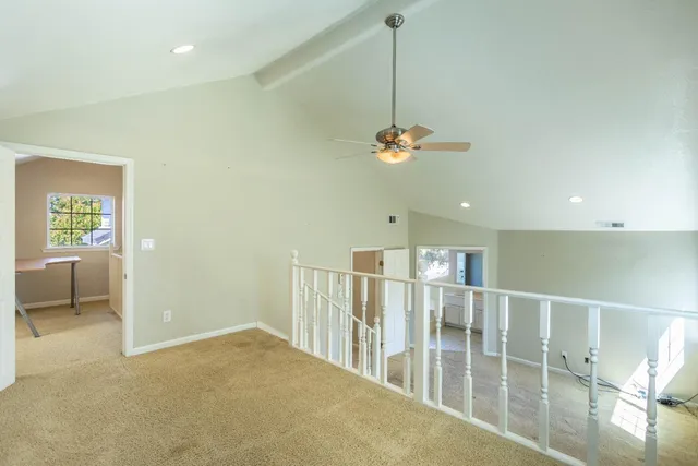 an empty room with a chandelier fan and closet