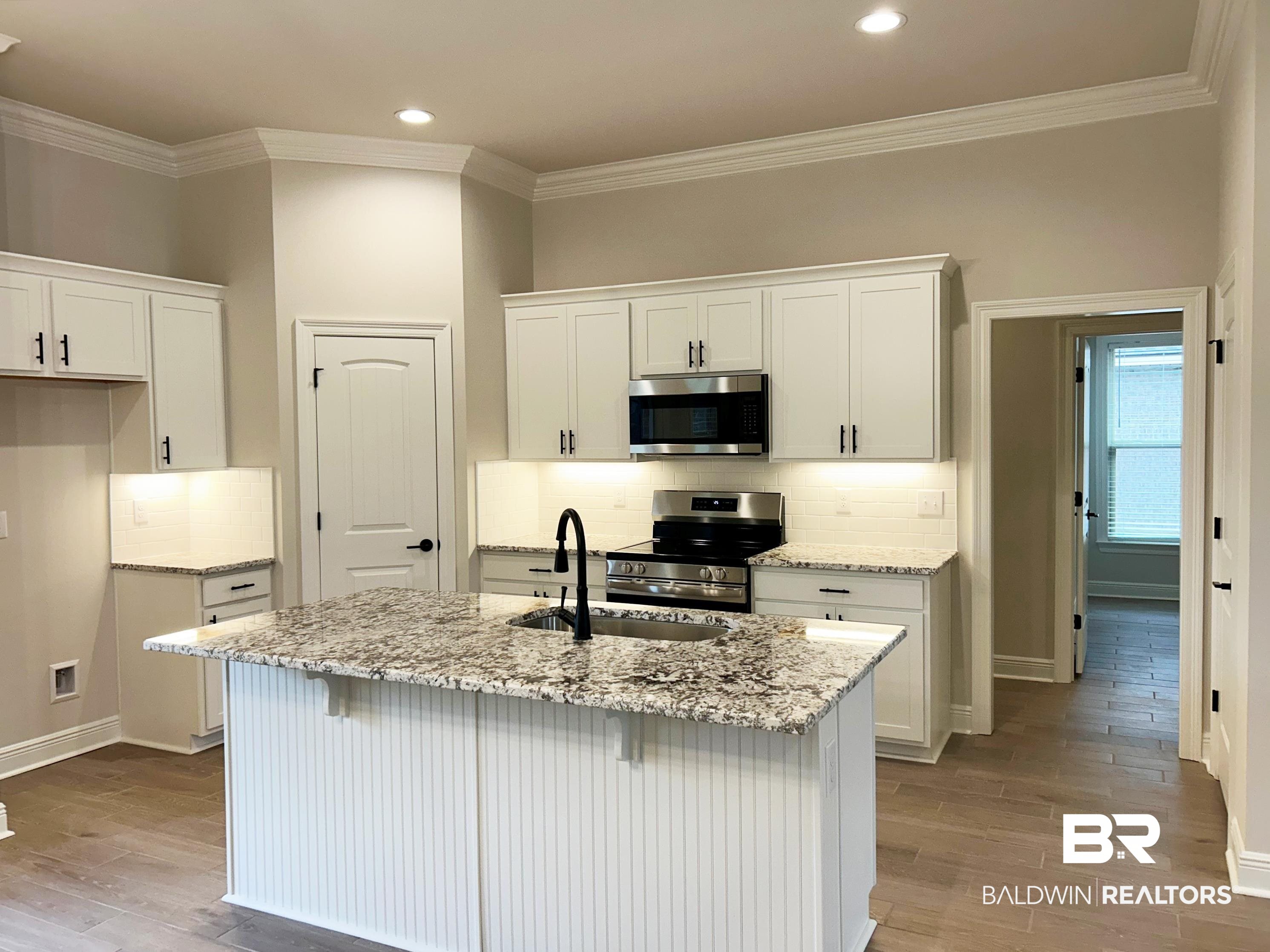 873 Sumter Loop Foley, AL 36535 - Photo 4 of 26 Kitchen featuring white cabinetry, backsplash, stainless steel appliances, light stone counters, and crown molding