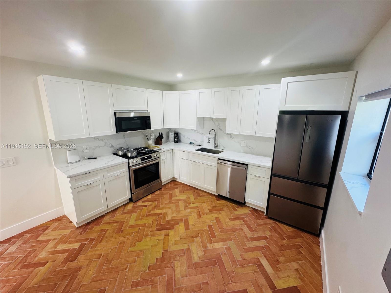 905 Southwest 13th Court Miami, FL 33135 - Photo 24 of 51 a kitchen with a refrigerator a stove top oven a sink and dishwasher