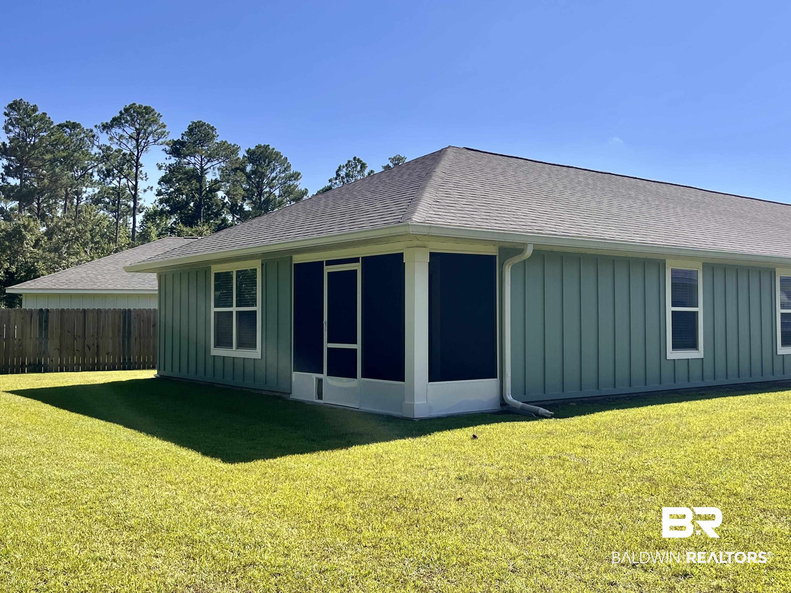 8891 Summer Bay Lane Foley, AL 36535 - Photo 44 of 54 Back of property with board and batten siding, a sunroom, and roof with shingles