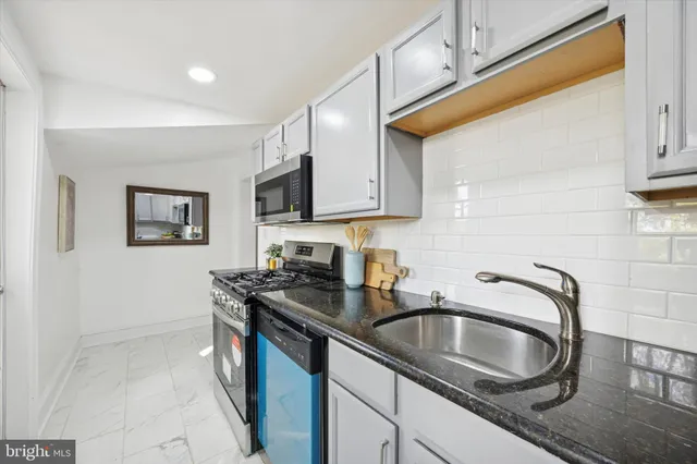 a kitchen with stainless steel appliances granite countertop a sink stove and cabinets