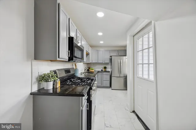 a kitchen with stainless steel appliances granite countertop a refrigerator sink and stove