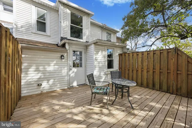a patio with table and chairs and potted plants