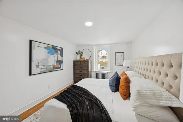 a bedroom with a bed and a painting on the wall