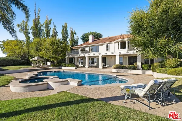 a view of a house with swimming pool and sitting area