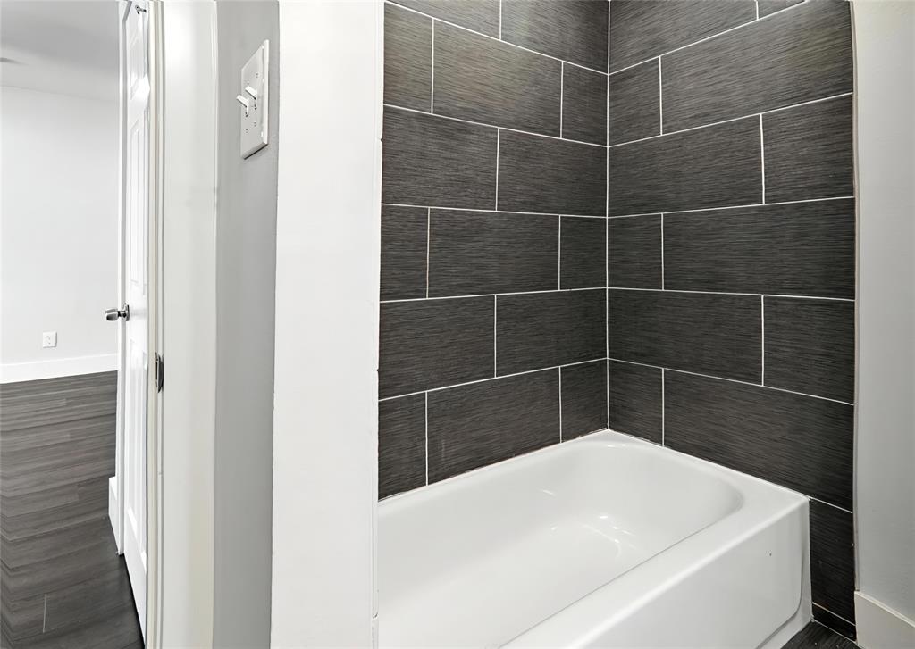 909 Reinli Street, Unit 144 Austin, TX 78751 - Photo 15 of 19 Bathroom featuring shower / washtub combination and wood finished floors