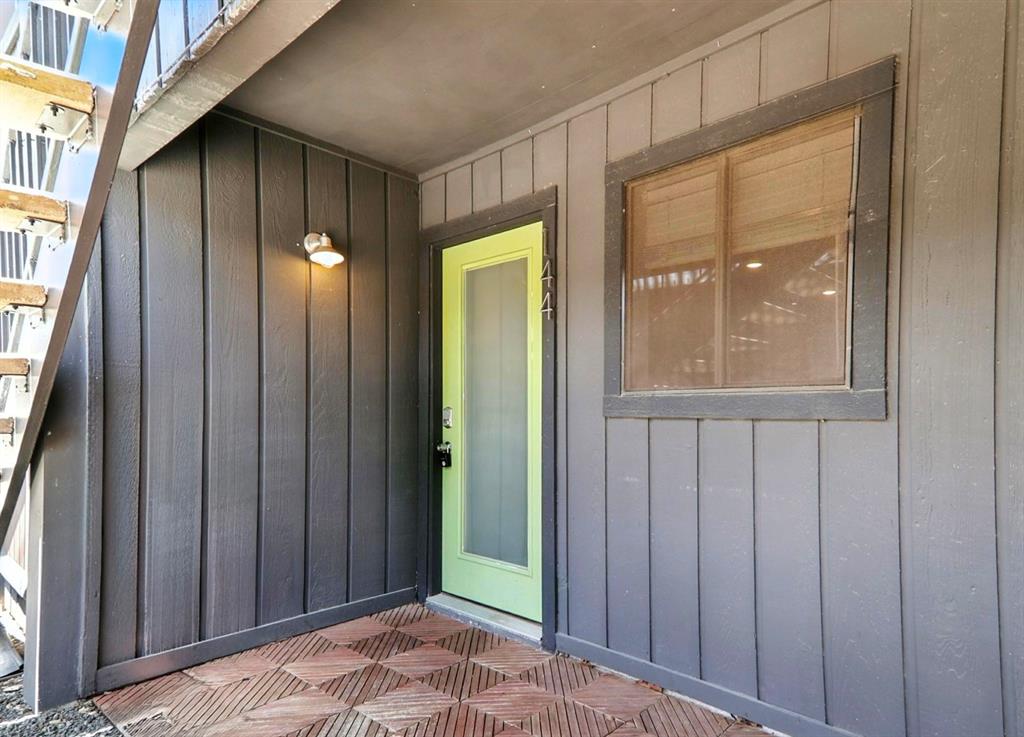 909 Reinli Street, Unit 144 Austin, TX 78751 - Photo 4 of 19 Doorway to property featuring board and batten siding and a patio
