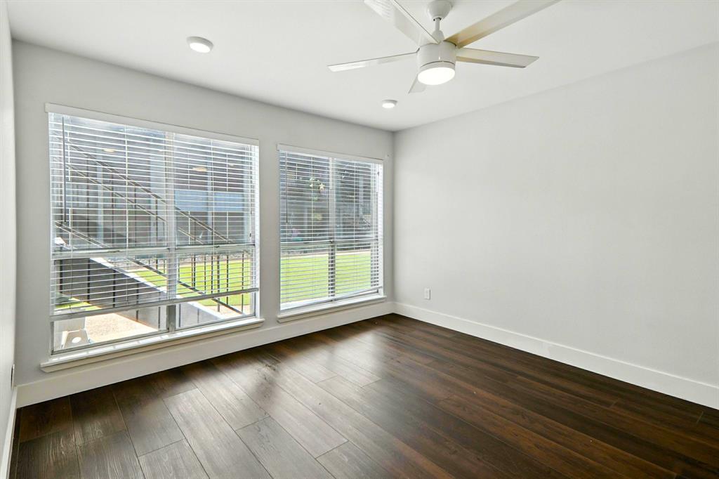 909 Reinli Street, Unit 144 Austin, TX 78751 - Photo 10 of 19 Empty room featuring dark wood-style flooring and a ceiling fan