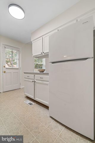 a kitchen with white cabinets and white appliances