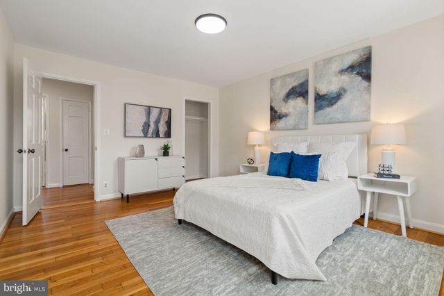 a spacious bedroom with a bed and wooden floor