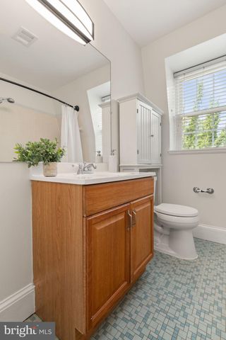 a bathroom with a granite countertop sink a toilet and a large mirror